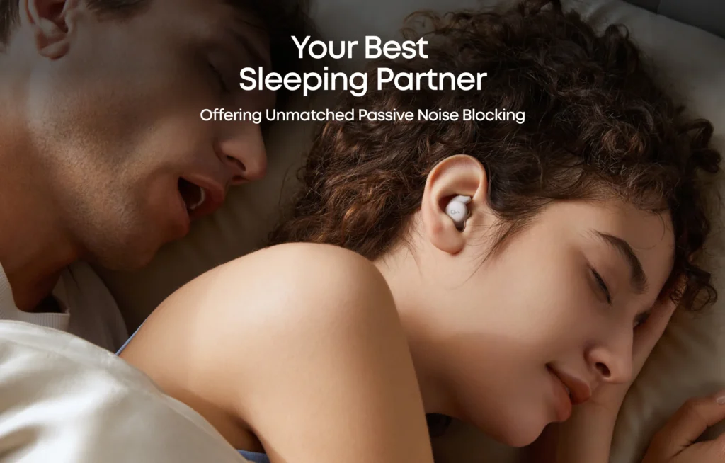 Vrouw slaapt ongestoord met Soundcore Sleep A20 oordopjes naast een snurkende partner – effectieve noise masking tegen snurken.